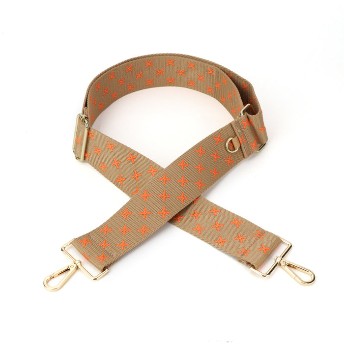 An orange XX and tan bag strap with gold metal hardware, displayed against a white background.