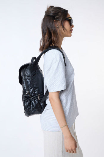 Person wearing a black backpack on a white background